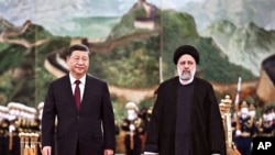 FILE - Visiting Iranian President Ebrahim Raisi walks with Chinese President Xi Jinping after reviewing an honor guard during a welcome ceremony at the Great Hall of the People in Beijing, Feb. 14, 2023. (Xinhua via AP)