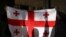 Activists hold a Georgian flag at a rally outside a parliament building during a plenary session of parliament on the controversial "foreign agents" bill, that sparked mass protests in recent days, in Tbilisi, Georgia, March 10, 2023.