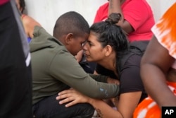 FILE - Venezuelan migrant Nelsy Zavala, right, embraces fellow Venezuelan migrant Yeikel Mojica, whom she met while crossing the Darien Gap and said is like a little brother to her, at a temporary camp in Lajas Blancas, Panama, June 27, 2024.