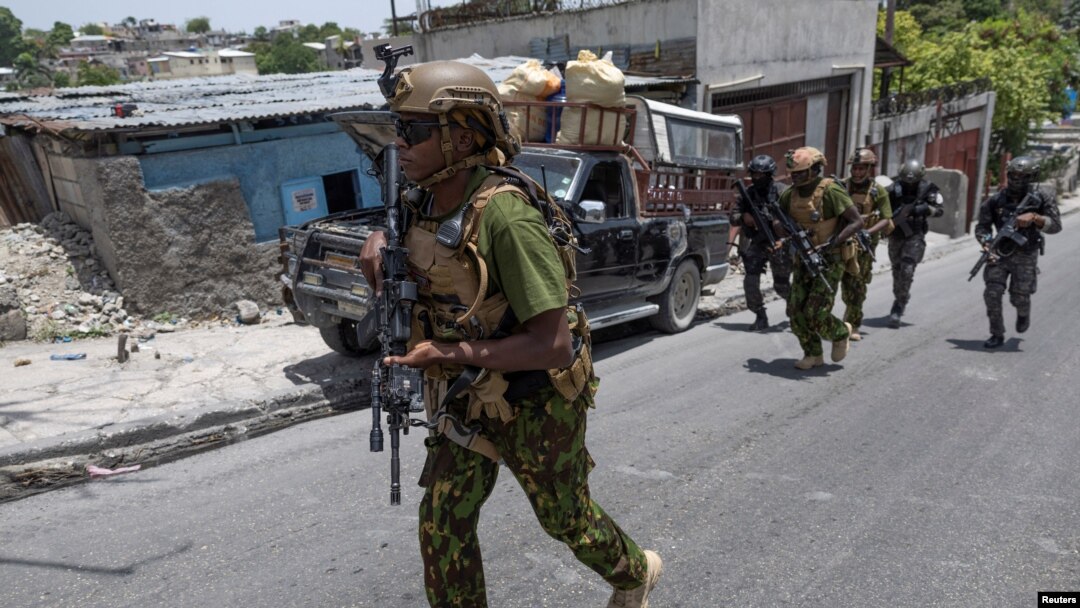 Inite SWAT Polis Nasyonal Ayiti, PNH ak polisye Kenyan yo grenpe yon morn pou monte nan yon blende pandan yo tap fe patwouy nan yon katye nan Potoprens, 28 Jyen 2024. 