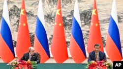El presidente chino Xi Jinping y el presidente ruso Vladimir Putin asisten a una ceremonia oficial tras sus conversaciones en Beijing, China, el 16 de mayo de 2024.