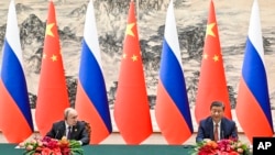 Chinese President Xi Jinping, right, and Russian President Vladimir Putin attend a signing ceremony following their talks in Beijing, China, on May 16, 2024. 