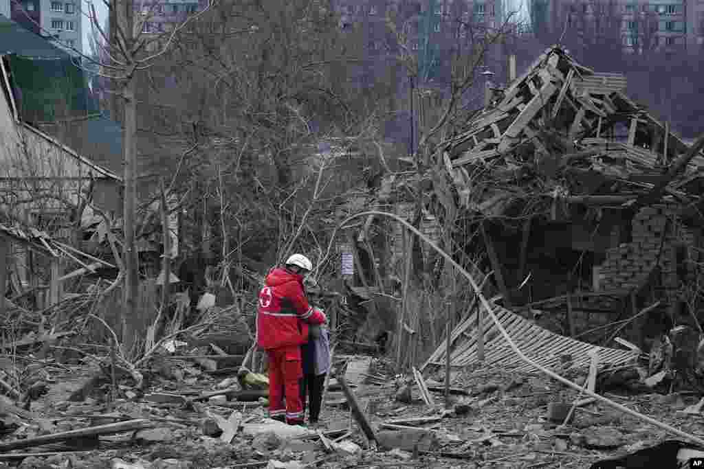 A medical worker comforts a woman at the site of Russia&#39;s air attack, in Zaporizhzhia, Ukraine. (AP Photo/Andriy Andriyenko)