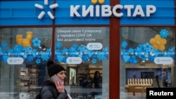 A woman walks past a store of Ukraine's telecommunications company Kyivstar, amid Russia's attacks on Ukraine, in Kyiv, Dec. 12, 2023.