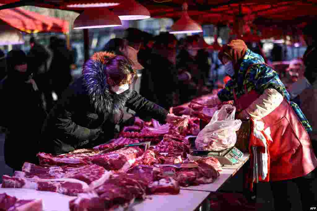 People shop for meat at a market in Shenyang in northeastern China's Liaoning province.