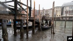 Passengers get off a gondola docked along a canal during a low tide in Venice, Italy.&nbsp;Some of Venice&#39;s secondary canals have practically dried up lately due a prolonged spell of low tides linked to a lingering high-pressure weather system.