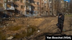 A crater in an apartment complex after a bomb sent mud and fire flying over the nearby buildings on Jan. 26, 2023 in Kherson, Ukraine.