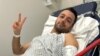 Pouria Zeraati, a presenter for independent Persian-language outlet Iran International, flashes a victory sign in a photo he posted of himself on X March 30, 2024, while hospitalized after a stabbing attack.