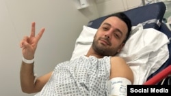 Pouria Zeraati, a presenter for independent Persian-language outlet Iran International, flashes a victory sign in a photo he posted of himself on X March 30, 2024, while hospitalized after a stabbing attack.