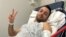Pouria Zeraati, a presenter for independent Persian-language outlet Iran International, flashes a victory sign in a photo he posted of himself on X March 30, 2024, while hospitalized after a stabbing attack.