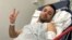 Pouria Zeraati, a presenter for independent Persian-language outlet Iran International, flashes a victory sign in a photo he posted of himself on X March 30, 2024, while hospitalized after a stabbing attack.