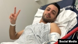 FILE - Pouria Zeraati, a presenter for independent Persian-language outlet Iran International, flashes a victory sign in a photo he posted of himself on X March 30, 2024, while hospitalized after a stabbing attack.