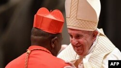 Papa François (D) ayambi episkopo ya lokumu ya diocèse ya Kinshasa Fridolin Ambongo na milulu mya "bokelami" bwa ye bo' cardinal, na Vaticain, Rome, 5 sanza ya zomi 2019. (Photo by Tiziana FABI / AFP)