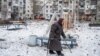 A woman walks on a playground after an apartment block was heavily damaged by a missile strike, amid Russia's attack on Ukraine, in Pokrovsk, Donetsk region, Feb. 15, 2023.