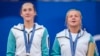 Mirra Andreeva and Diana Shnaider of Individual Neutral Athlete show their silver medals after losing to Sara Errani and Jasmine Paolini of Italy after women's doubles gold medal tennis match at Roland Garros stadium, at the 2024 Summer Olympics, Aug. 4, 2024, in Paris, France. 