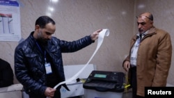 Officials work after the close of the polling station during Iraq's provincial council elections, in Mosul, Iraq Dec. 18, 2023.