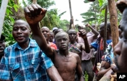 Daniel Wabuyi camina por las aldeas antes de su ritual tradicional de circuncisión, conocido como Imbalu, en la aldea de Kamu en Mbale, este de Uganda, el 3 de agosto de 2024.