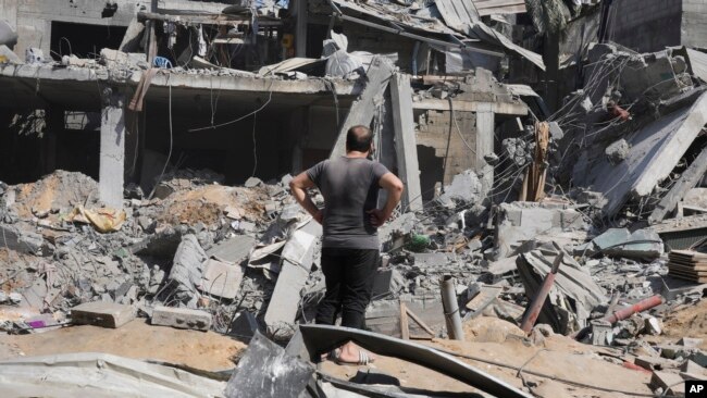 A Palestinian man looks at the remnants of a building destroyed by Israeli bombardment of the Gaza Strip, at the Maghazi refugee camp, in Deir Al-Balah, Oct. 25, 2023.