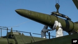 FILE - Troops load an Iskander missile onto a launcher at an undisclosed site in Russia, in this photo released Feb. 2, 2024. Hawks in Russia have called for lowering the threshold for using nuclear weapons. (Russian Defense Ministry Press Service/AP)