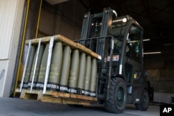 FILE - U.S. airmen with the 436th Aerial Port Squadron use a forklift to move 155 millimeter shells ultimately bound for Ukraine on April 29, 2022, at Dover Air Force Base, Delaware. Without new funds approved by Congress, U.S. aid to Ukraine will have de facto halted.