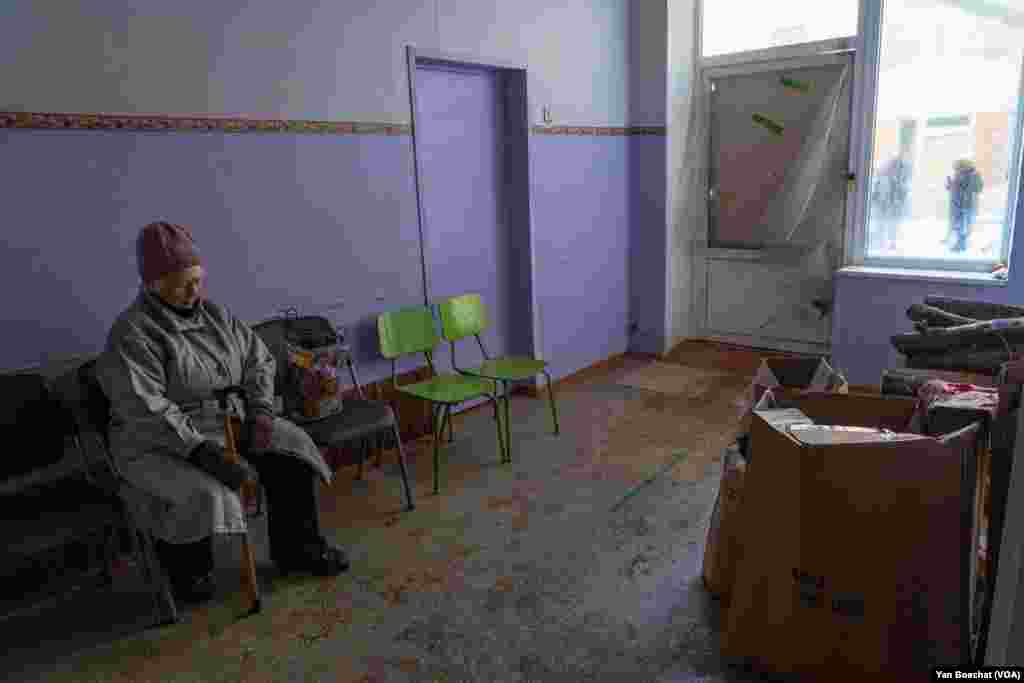 An elderly woman rests in a humanitarian center before heading back home on a cold morning in Kupiansk, Feb. 17, 2023.