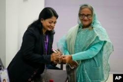 A Bangladeshi polling officer puts indelible ink on the finger of Bangladesh Prime Minister Sheikh Hasina after arriving to cast her vote in Dhaka, Jan. 7, 2024.