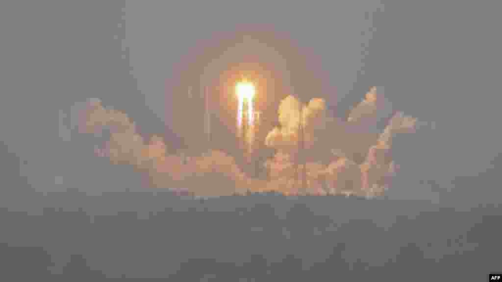 A Long March 5 rocket, carrying the Chang&#39;e-6 mission lunar probe, lifts off as it rains at the Wenchang Space Launch Centre in southern China&#39;s Hainan Province. (Photo by Hector RETAMAL / AFP)