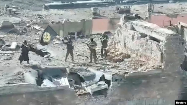 俄罗斯的瓦格纳集团发布视频截图显示其瓦格纳雇佣兵在巴赫穆特的废墟上挥舞旗帜。 （2023年3月2日）