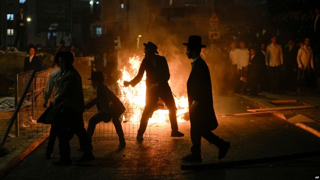 Ultra-Orthodox Jewish men burn trash during a protest against army recruitment, in Jerusalem, June 30, 2024. 