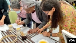 Para pengunjung belajar membatik dalam rangka memeriahkan "Hari Batik" yang diperingati di kantor pusat Bank Dunia (World Bank), Washington, D.C., 3 Oktober 2023 (VOA/Eva)