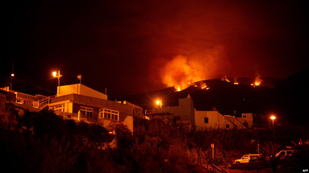 A picture taken in the night of Aug. 19, 2023, shows the fronts of the forest fire on hills above houses, in the Guimar valley on the Canary Island of Tenerife. 