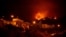 A picture taken in the night of Aug. 19, 2023, shows the fronts of the forest fire on hills above houses, in the Guimar valley on the Canary Island of Tenerife. 