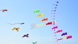 People gather during a kite festival on Ao Manao Beach in the southern Thai province of Narathiwat.