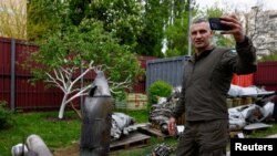 乌克兰基辅市长维塔利·克利奇科（Vitalii Klitschko）在被乌军击落的俄罗斯高超音速“匕首”导弹残骸碎片前自拍。（2023年5月12日）