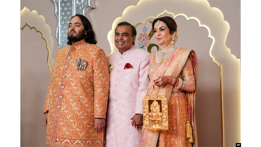 Billionaire Mukesh Ambani, center, poses with son Anant and wife Nita at Anant Ambani and Radhika Merchant's wedding at Jio World Convention Centre in Mumbai, India, July 12, 2024.