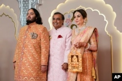 Billionaire Mukesh Ambani, center, poses with son Anant and wife Nita at Anant Ambani and Radhika Merchant's wedding at Jio World Convention Centre in Mumbai, India, July 12, 2024.