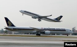 Pesawat Singapore Airlines Airbus A330-300 lepas landas di belakang Boeing 787-10 Dreamliner di Bandara Changi di Singapura, 28 Maret 2018. (Foto: REUTERS/Edgar Su)