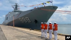 Chinese naval personnel line up in front of their warship, docked at the port of Sihanoukville, Cambodia, May 19, 2024. Two Chinese warships docked at the port Sunday.