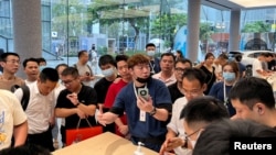 深圳一家華為商店的店員在向人們展示Mate 60系列手機。（2023年8月30日）