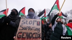 FILE - A person holds a placard as pro-Palestinian protesters gather near the International Court of Justice (ICJ) as judges hear a request for emergency measures by South Africa to order Israel to stop its military actions in Gaza, in The Hague, Netherlands January 12, 2024.