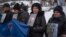 FILE - Relatives of Ukrainian soldiers who were captured by Russia hold their photos demanding they be freed, at a rally in central Kyiv, Ukraine, Dec. 10, 2023.