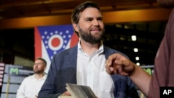 FILE - J.D. Vance, the venture capitalist and author of "Hillbilly Elegy," holds his book as he speaks with supporters after a rally, July 1, 2021, in Middletown, Ohio, where he announced he is joining the crowded Republican race for the Ohio U.S. Senate seat. 