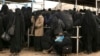 FILE - Female residents from former Islamic State-held areas in Syria line up for aid at al-Hol camp in Hasakah province, Syria, March 31, 2019.