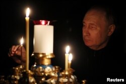 Russian President Vladimir Putin holds a national day of mourning and lights candles in memory of the victims of the attack on the Krokus City Hall in a church at his official residence in the Novo-Ogaryovo region on March 24, 2024 .  (Sputnik/Mikhail Metzer/Pool via Reuters)