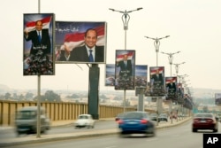 Vehicles pass under billboards showing Egyptian President Abdel Fattah el-Sissi with Arabic which reads, "Our common goal is Egypt: our dream and hope" at a new highway in Cairo, Egypt, Wednesday, Feb. 22, 2023.