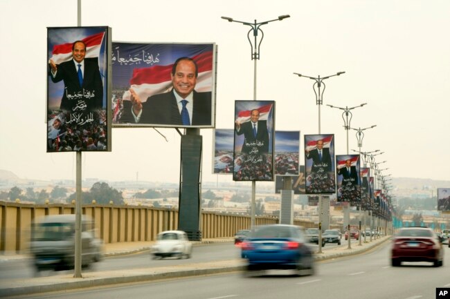 Vehicles pass under billboards showing Egyptian President Abdel Fattah el-Sissi with Arabic which reads, "Our common goal is Egypt: our dream and hope" at a new highway in Cairo, Egypt, Wednesday, Feb. 22, 2023.