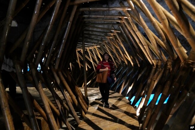 A woman walks inside an installation at the Philippine pavilion, at the Biennale International Architecture exhibition, in Venice, Italy, May 17, 2023.