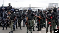 Police officers stand guard during a protest in Lagos, Nigeria, Aug. 1, 2024.