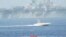 A Revolutionary Guard speedboat moves near USS Bataan at the Strait of Hormuz.