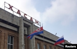 Bendera Rusia dan Korea Utara berkibar di stasiun kereta api dekat perbatasan kedua negara, di pemukiman timur jauh Khasan, Rusia, 23 April 2019. (Foto: REUTERS)